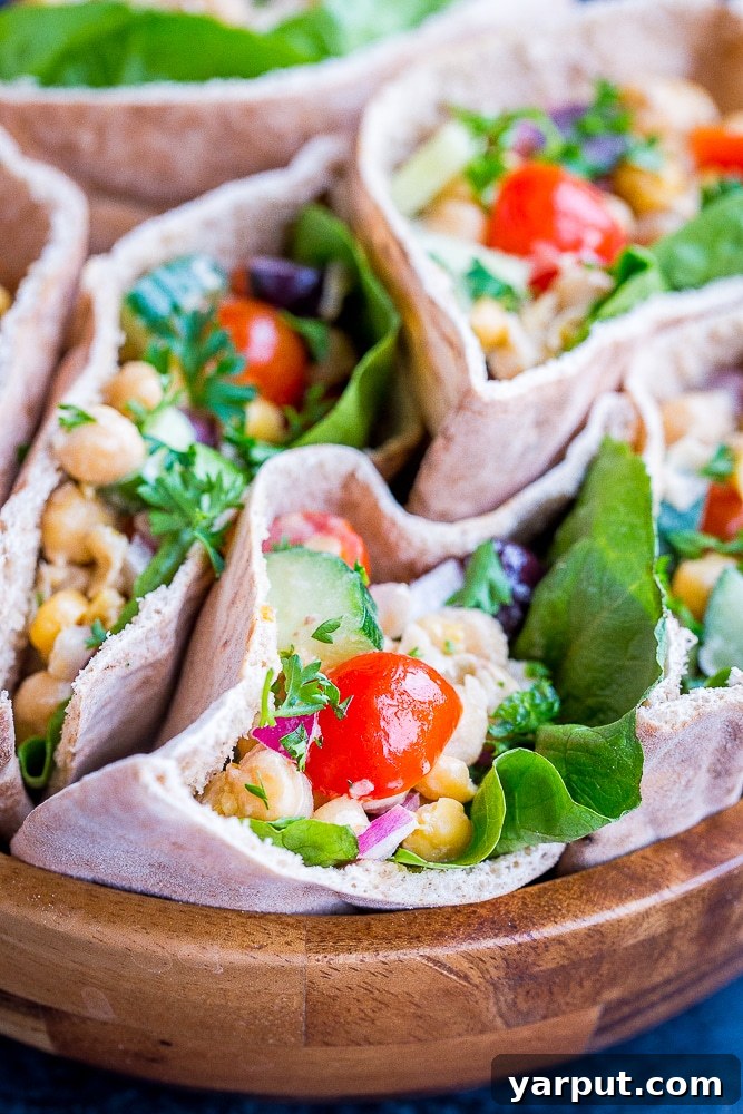 A vibrant close-up view of a Greek Chickpea Salad Pita, showcasing the abundant chickpea filling, fresh vegetables, and fluffy pita bread, ready for a healthy and satisfying meal.