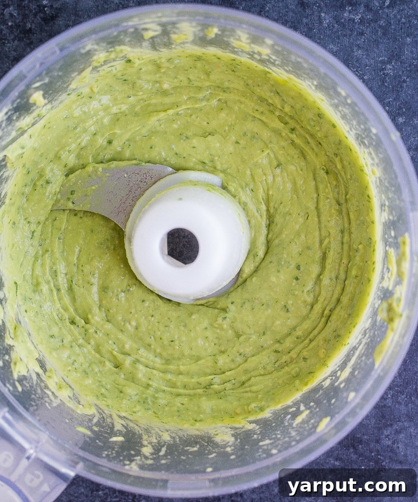 Whip Up Delicious Avocado Pesto 4 A vibrant bowl of Vegan Avocado Pesto Sauce, showcasing its smooth texture and rich green color, ready to be served.