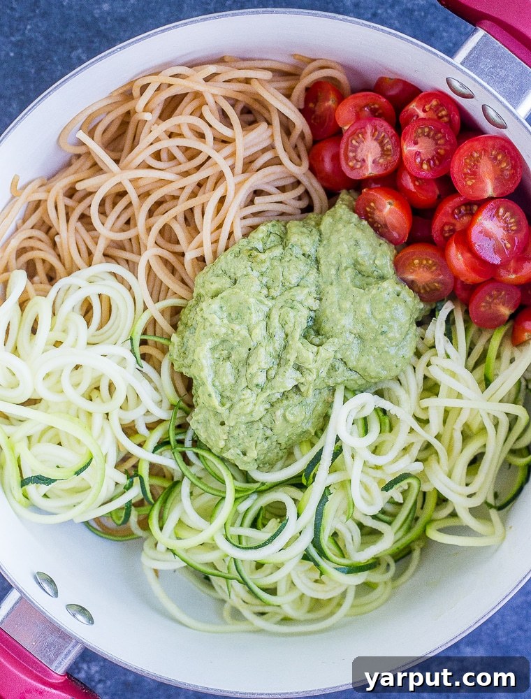 20 Minute Creamy Avocado Pesto Zucchini Noodles 5 All the fresh ingredients for Avocado Pesto Zucchini Noodles, including pasta, zoodles, cherry tomatoes, and pesto, mixed in a large pot.