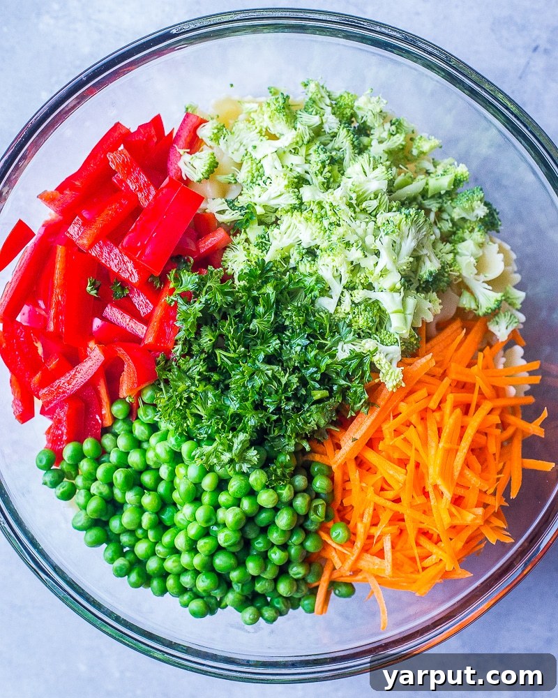 Vibrant Vegan Primavera Pasta Salad 3 A vibrant assortment of fresh, raw spring vegetables in a bowl, ready to be incorporated into a healthy Primavera Pasta Salad.