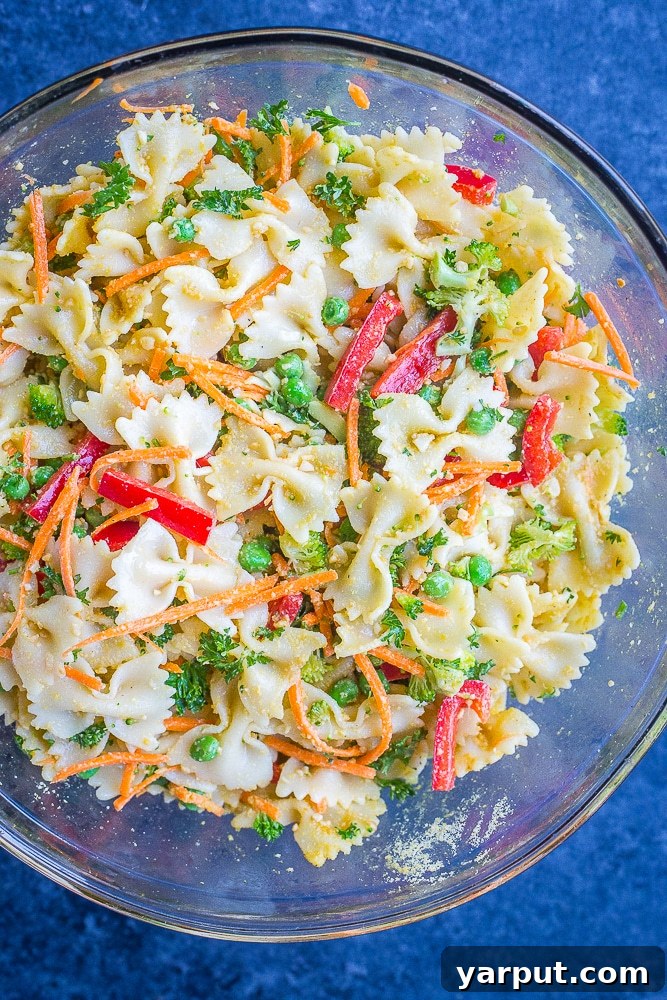 Vibrant Vegan Primavera Pasta Salad 4 A large mixing bowl filled with the colorful, mixed Vegan Primavera Pasta Salad, showing off its fresh ingredients.
