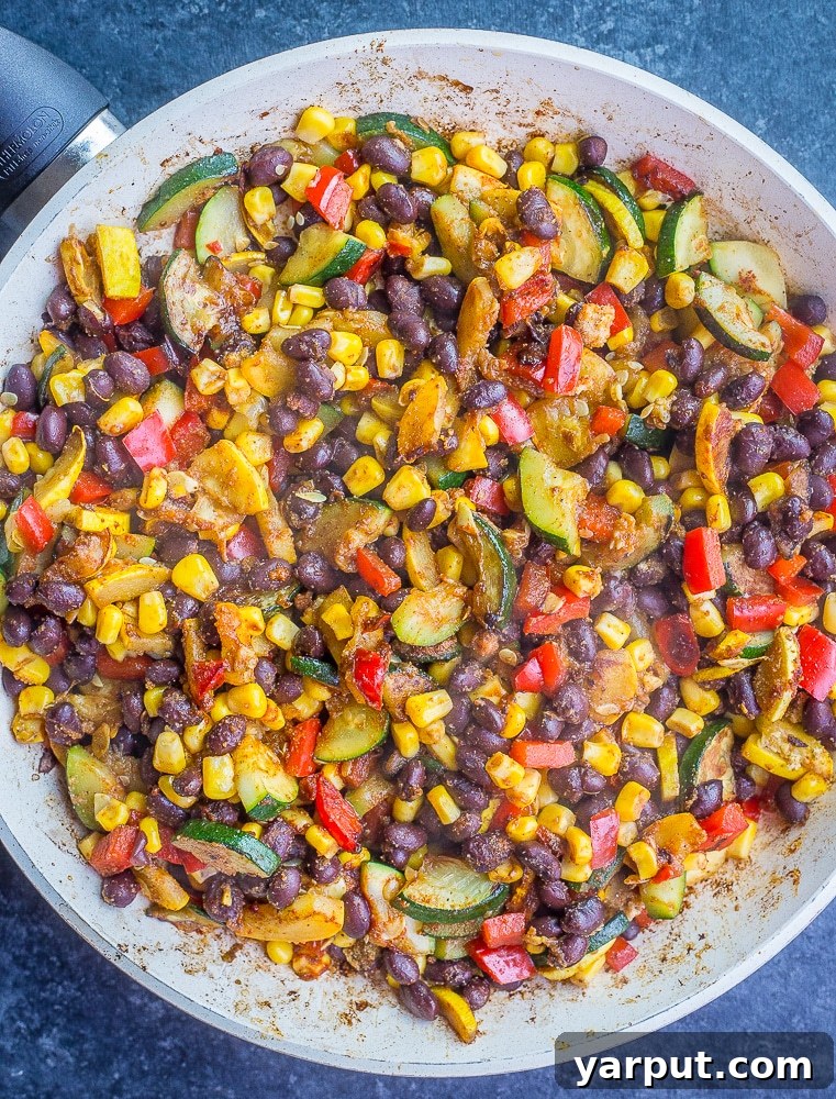 Vibrant Summer Vegan Black Bean Tacos 4 A vibrant close-up of the cooked vegan black bean and summer vegetable filling simmering in a pan, ready for taco assembly