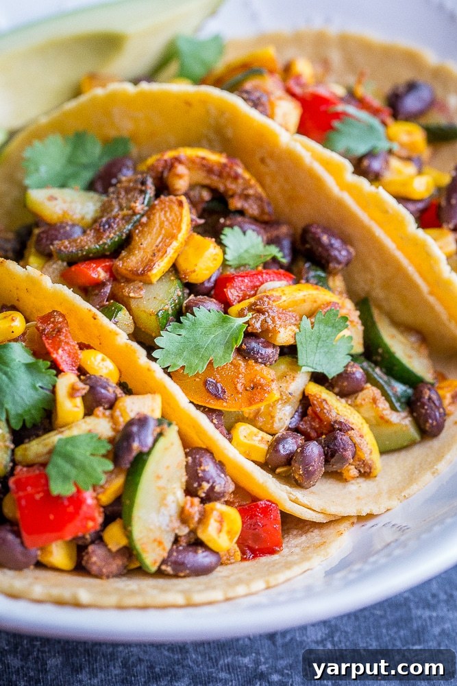 Vibrant Summer Vegan Black Bean Tacos 5 A close-up of a single Vegan Black Bean Taco with summer vegetables, avocado, and cilantro, highlighting the vibrant colors and fresh ingredients