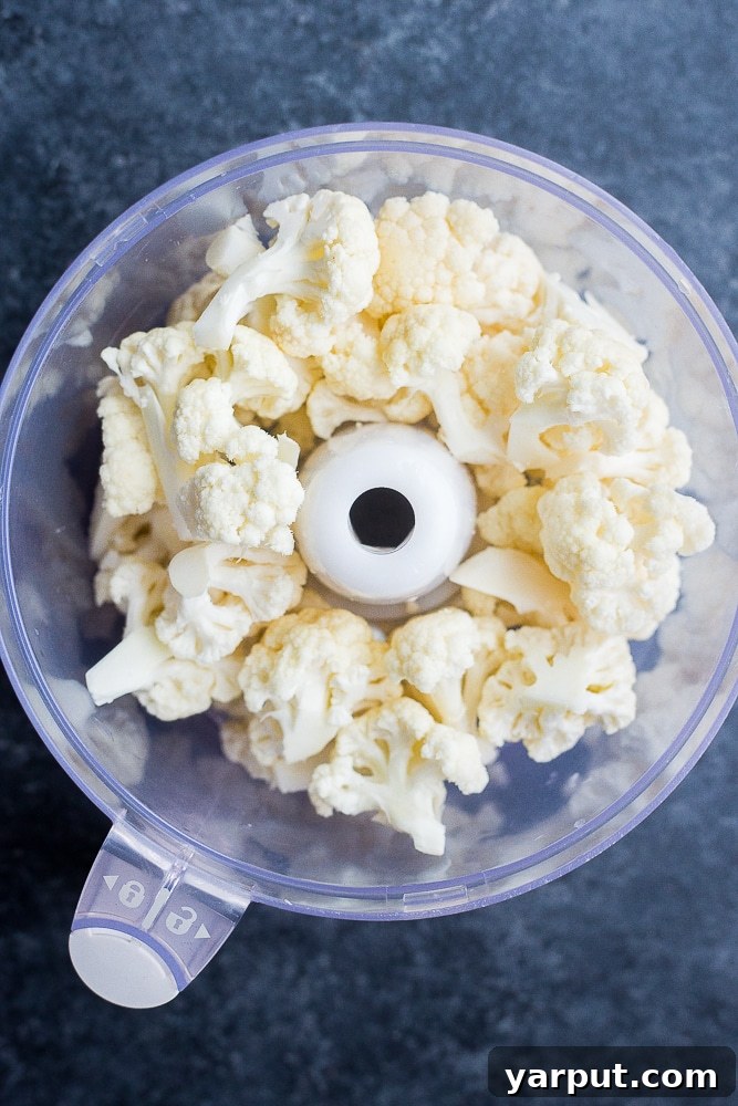Crafting Delicious Cauliflower Rice 4 Food processor filled with evenly cut cauliflower florets, ready to be pulsed into rice