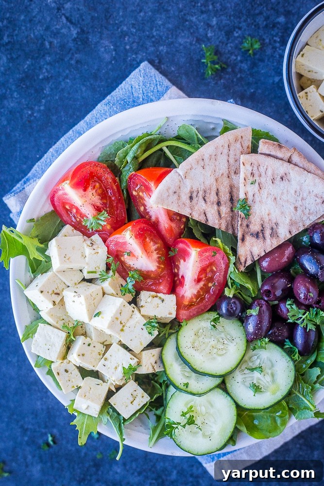 Homemade Vegan Feta Perfection 2 A vibrant Greek salad served in a white bowl, generously topped with homemade vegan feta cheese