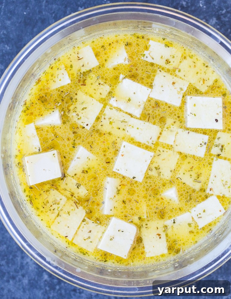 Homemade Vegan Feta Perfection 5 Cubed tofu soaking in a rich, flavorful vegan feta cheese marinade in a glass bowl
