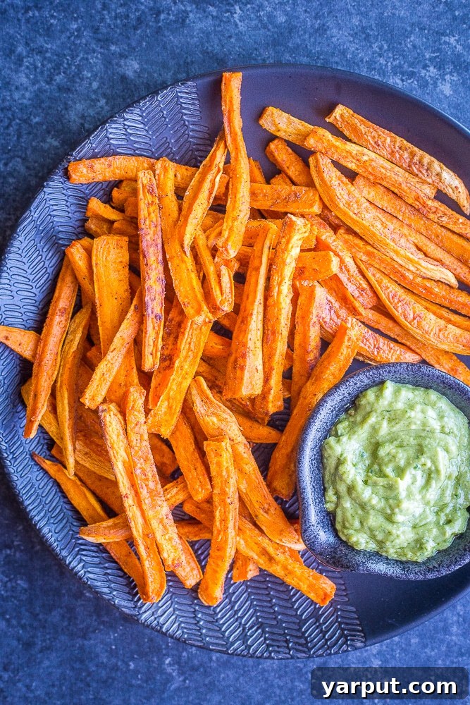 Golden Crispy Baked Sweet Potato Fries 2 A vibrant plate of perfectly baked sweet potato fries, golden and crispy, garnished slightly