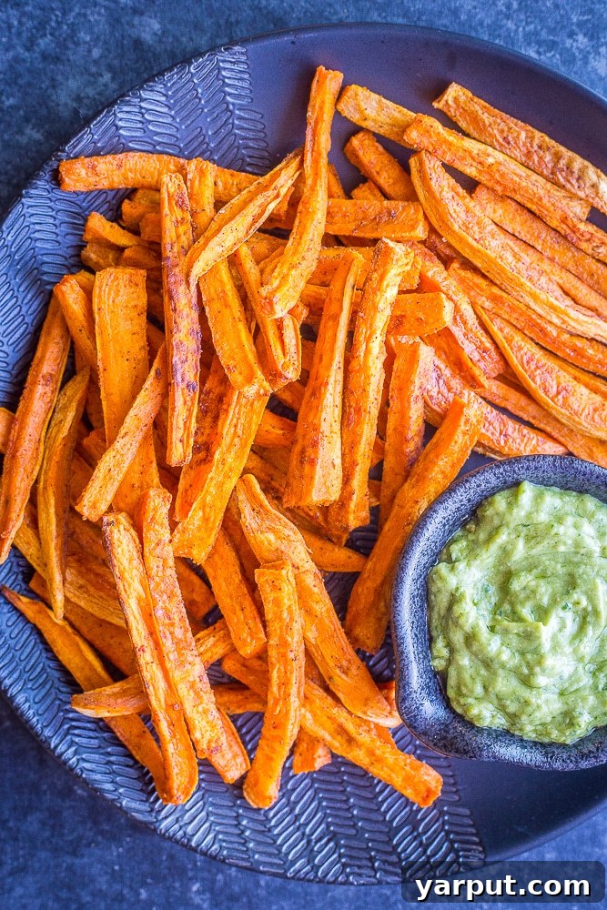 Golden Crispy Baked Sweet Potato Fries 5 A large serving plate overflowing with golden, crispy baked sweet potato fries, ready to be enjoyed