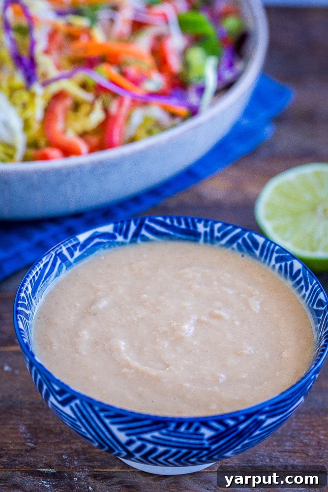 Homemade Peanut Sauce Perfection 5 Best homemade peanut sauce in a bowl with a salad in the background