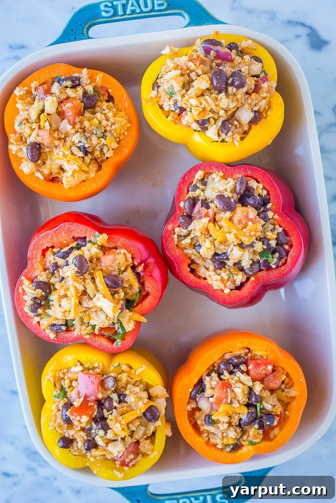 Wholesome Cauliflower Rice Stuffed Peppers 5 Vegetarian stuffed peppers arranged neatly in a baking pan, ready to be placed in the oven.