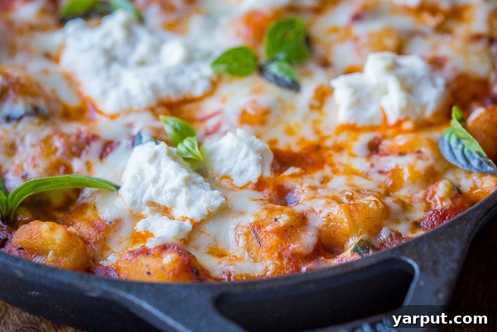 30-Minute Skillet Gnocchi Lasagna 5 Close up of gnocchi lasagna bake in a skillet, showing the bubbly cheese and sauce