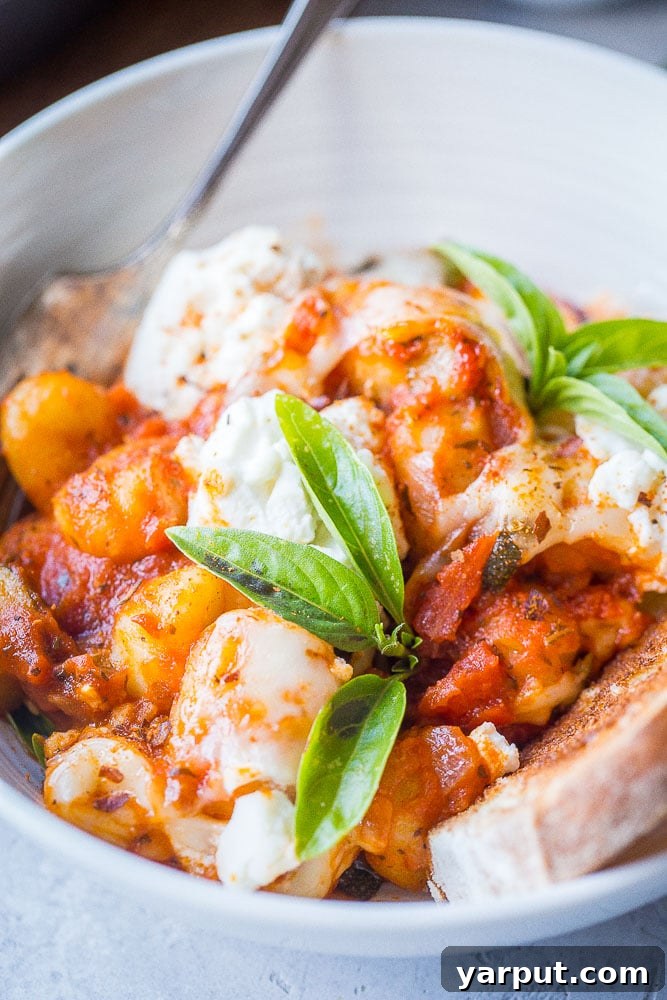 30-Minute Skillet Gnocchi Lasagna 6 Close up of gnocchi lasagna bake in a bowl with fresh basil and crusty bread