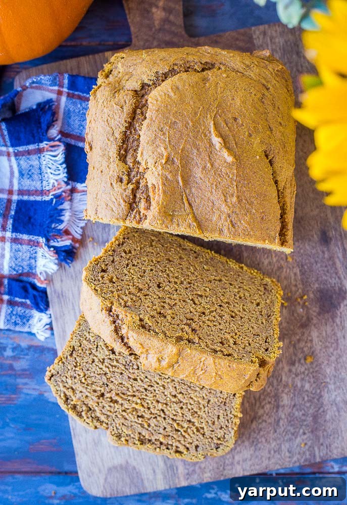 Simple One-Bowl Naturally Sweetened Pumpkin Bread 2 Healthy Pumpkin Bread with two slices taken out, showcasing its moist texture and golden crust.