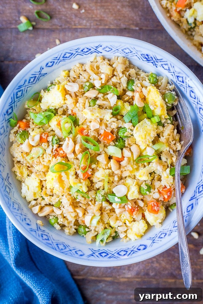 Wholesome Cauli Fried Rice 2 Delicious Vegetarian Cauliflower Fried Rice served in a bowl with a fork, ready to eat.