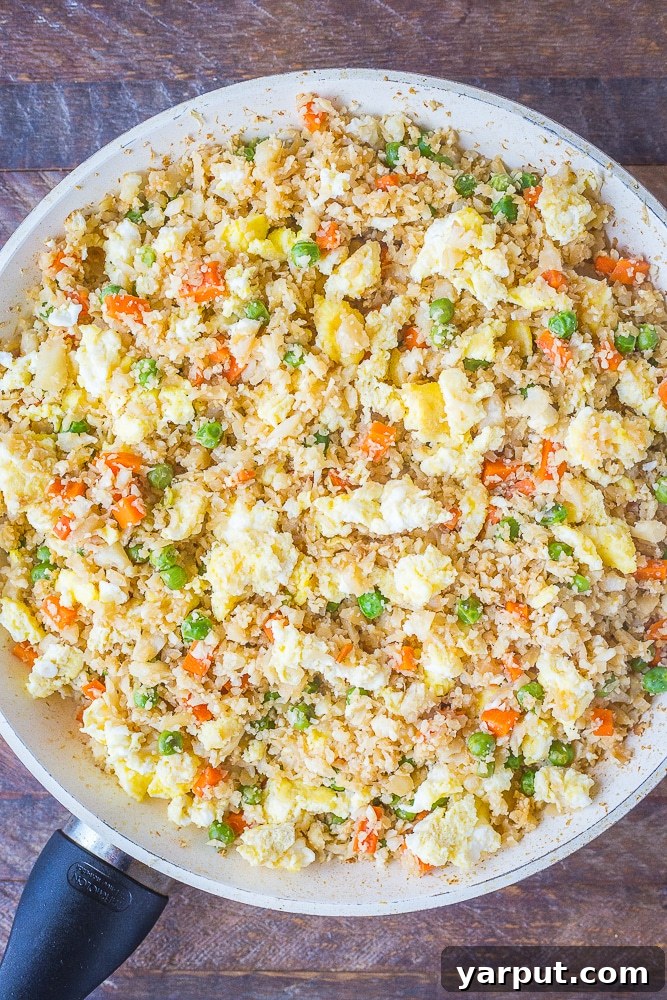 Wholesome Cauli Fried Rice 4 A large pan filled with freshly cooked Vegetarian Cauliflower Fried Rice, steaming and ready to serve.