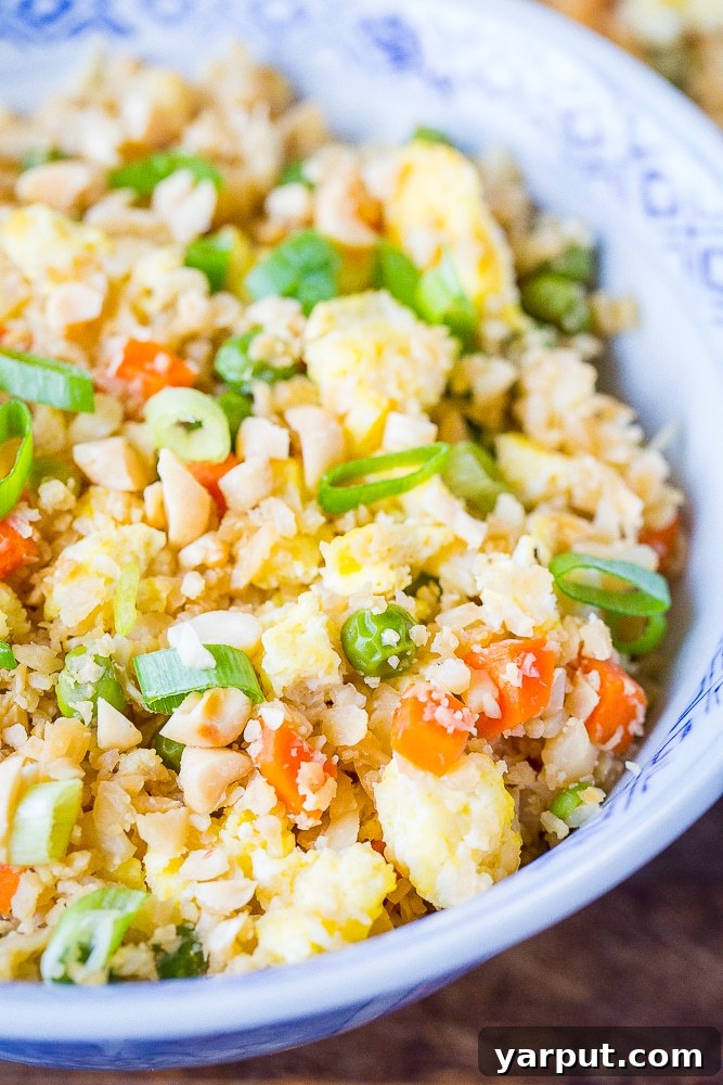 Wholesome Cauli Fried Rice 5 A close-up view of a serving of Vegetarian Cauliflower Fried Rice in a bowl, showcasing its colorful ingredients and appetizing texture.