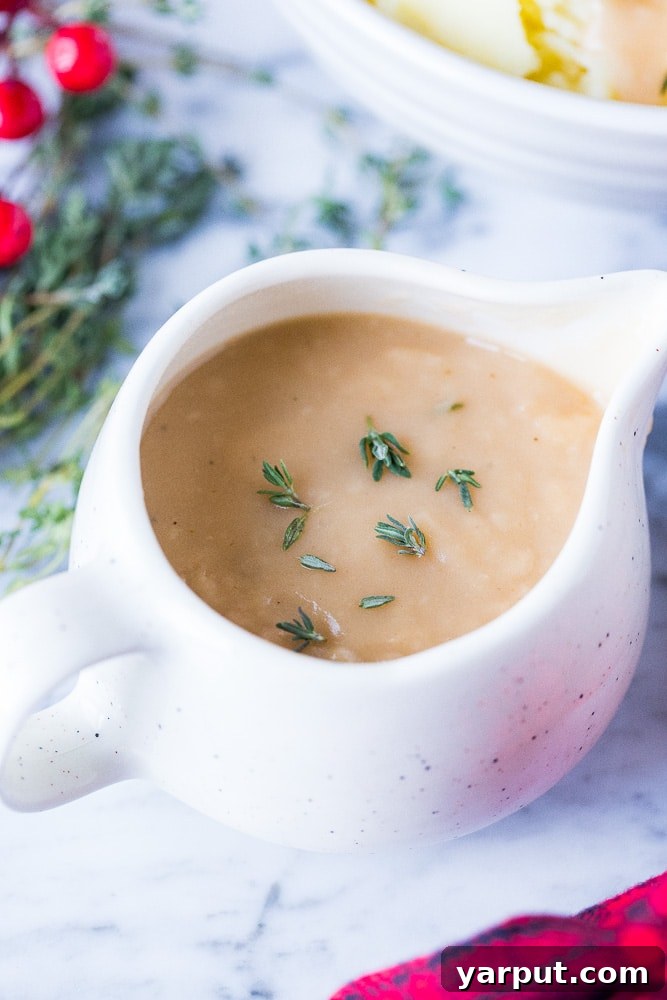 Effortless & Flavorful Vegan Gravy 4 A close-up view of a small saucer brimming with smooth, golden-brown vegan gravy, showcasing its appetizing color and perfect, lump-free texture.