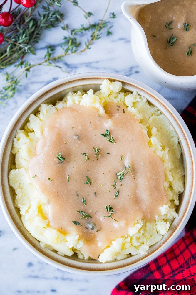Effortless & Flavorful Vegan Gravy 5 A beautifully composed bowl of creamy mashed potatoes generously topped with warm, homemade vegan gravy, ready to be enjoyed as a comforting meal.
