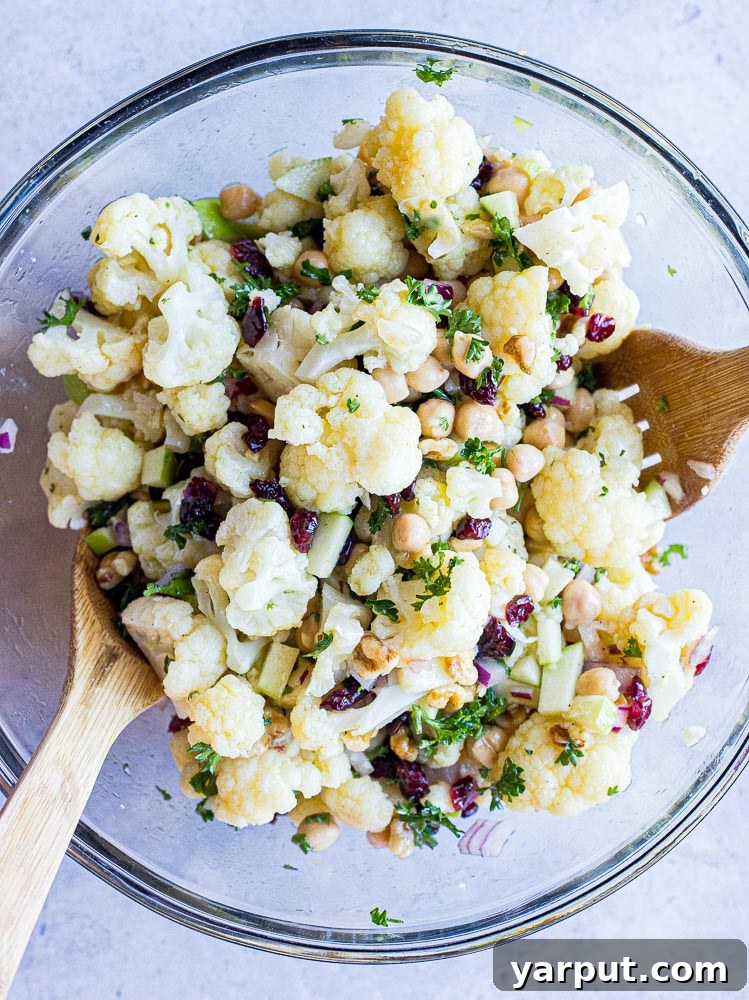 Golden Curried Cauliflower Salad 4 Curried cauliflower salad mixed thoroughly in a large bowl, ready for serving.
