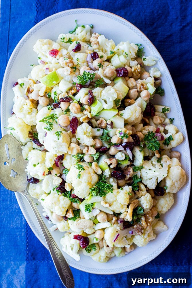 Golden Curried Cauliflower Salad 5 A plated serving of Curried Cauliflower Salad with a serving spoon, ready to be enjoyed as a side dish.
