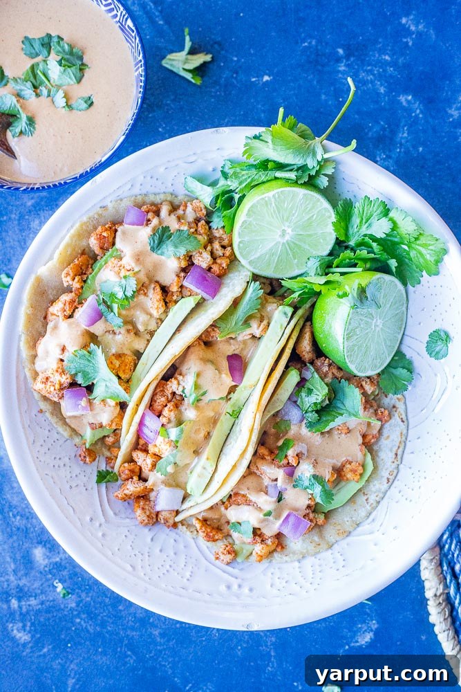Tahini Cheesy Vegan Tacos 5 A beautifully arranged bowl of vegan tacos, overflowing with colorful toppings and drizzled with a creamy tahini cheese sauce, ready to be enjoyed.