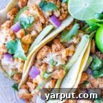 A top-down view of a completed vegan taco recipe, possibly in a small bowl or on a plate, featuring the tahini cheese sauce prominently.