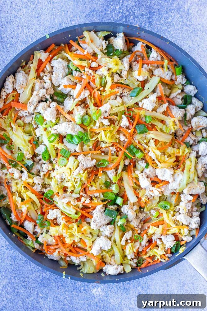Plant-Based Egg Roll Stir-Fry Bowl 4 A large skillet filled with the cooked Vegetarian Egg Roll in a Bowl mixture, featuring tender cabbage, carrots, seasoned tofu, and green onions, ready to be served.