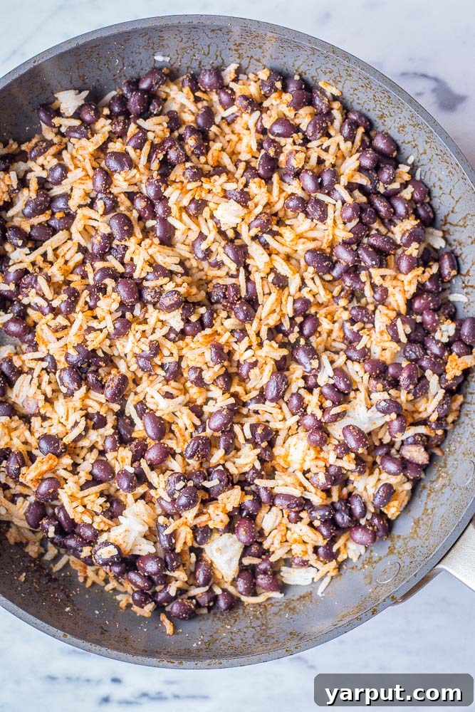 No-Fuss Rice and Bean Quesadillas 3 A close-up shot of a large pan filled with seasoned rice and black beans, ready to be used as a delicious quesadilla filling.