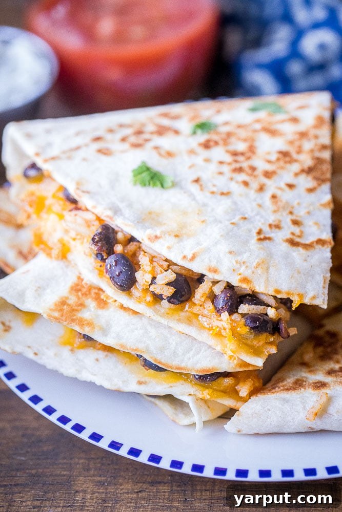 No-Fuss Rice and Bean Quesadillas 6 A close-up shot revealing the delicious, melted cheese and hearty rice and bean filling inside a freshly sliced quesadilla, highlighting its texture and warmth.