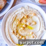 A small bowl of creamy hummus with a side of pita bread