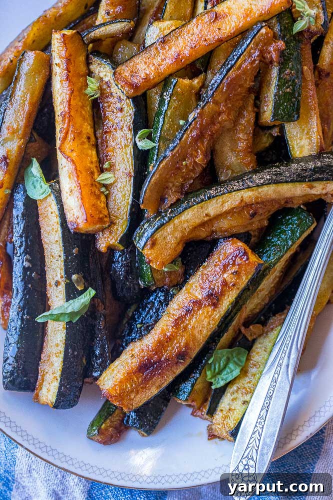 Perfectly Roasted Zucchini 6 A close-up shot of a plate brimming with perfectly golden and tender roasted zucchini, highlighting its delicious appearance.