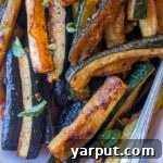 Plate of roasted zucchini with caramelized edges.