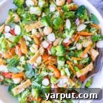 A small bowl of Asian Broccoli Salad with a fork