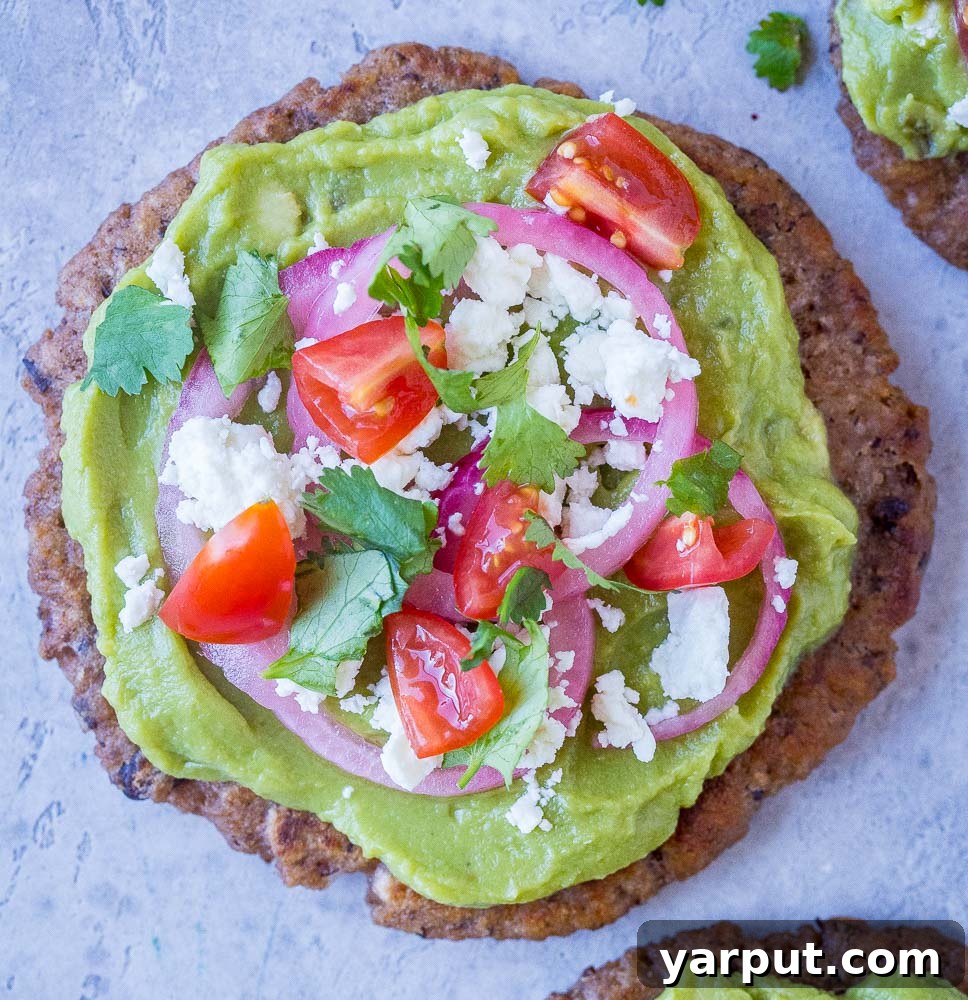 Vibrant Guacamole Tostadas with Black Bean Crisps 5 A close-up shot of a Guacamole Tostada, beautifully adorned with a variety of fresh and colorful toppings.