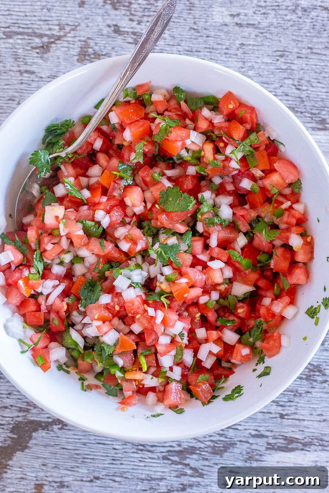 Vibrant Homemade Pico De Gallo 4 A beautifully presented large bowl of homemade Pico de Gallo, rich in red tomatoes, white onions, green cilantro, and subtle specks of jalapeño, ready to be served.