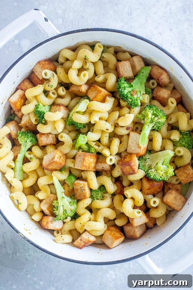 A large pot filled with the combined ingredients of Tofu Broccoli Pasta: golden-brown tofu, tender-crisp broccoli, and al dente pasta, ready for final seasoning
