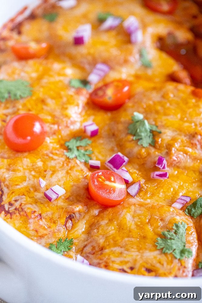A close-up shot of a single serving of the baked Polenta Enchilada Bake, showing the melted cheese, vibrant vegetables, and the distinct polenta base.