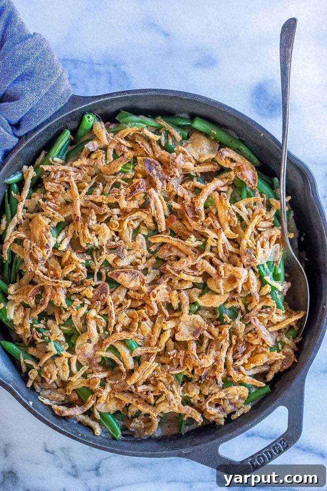 Ultimate Vegan Green Bean Casserole 6 A rustic shot of the homemade vegan green bean casserole, served directly from a cast-iron skillet, highlighting its wholesome, comforting appeal.