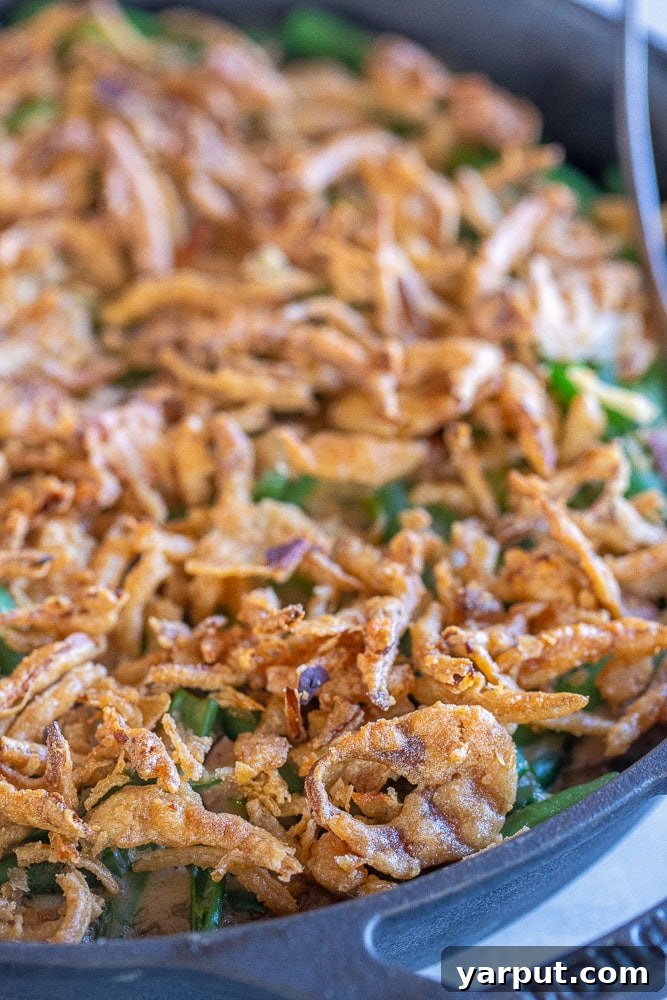 Ultimate Vegan Green Bean Casserole 7 A close-up view of the golden, crispy fried onions topping the vegan green bean casserole, showcasing its irresistible texture.
