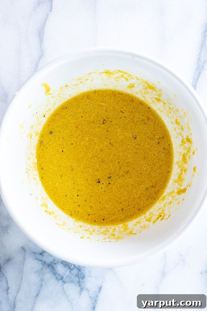 Close-up view of the creamy vegan lemon garlic sauce in a bowl, highlighting its smooth texture and rich color, ready to be mixed with pasta.