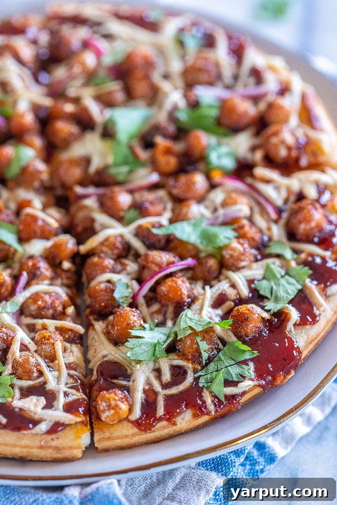 Smoky BBQ Chickpea Pizza 5 A close-up view of a single slice of BBQ Chickpea pizza, highlighting the vibrant toppings and crispy crust