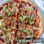 BBQ Chickpea Pizza on a white background with a small garnish