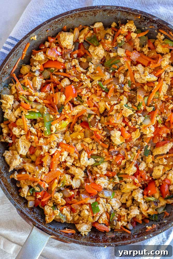 Korean Tofu & Veggie Power Bowls 4 A pan filled with perfectly cooked Korean-inspired tofu and a mix of colorful vegetables coated in a rich, savory sauce.