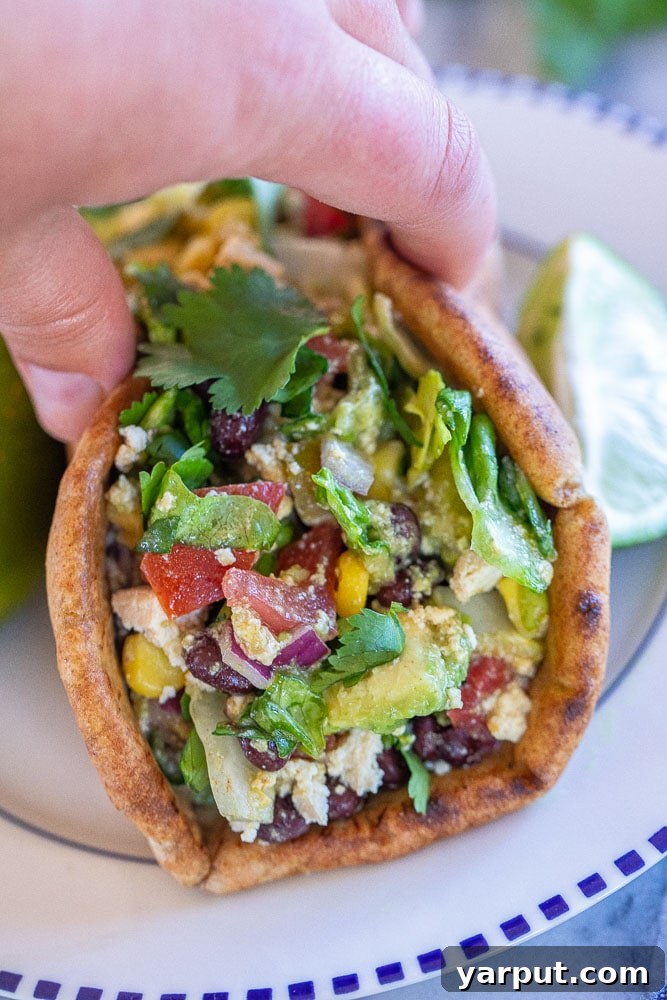Southwest Salad Pockets 6 A hand holding a perfectly filled Mexican chopped salad pita sandwich