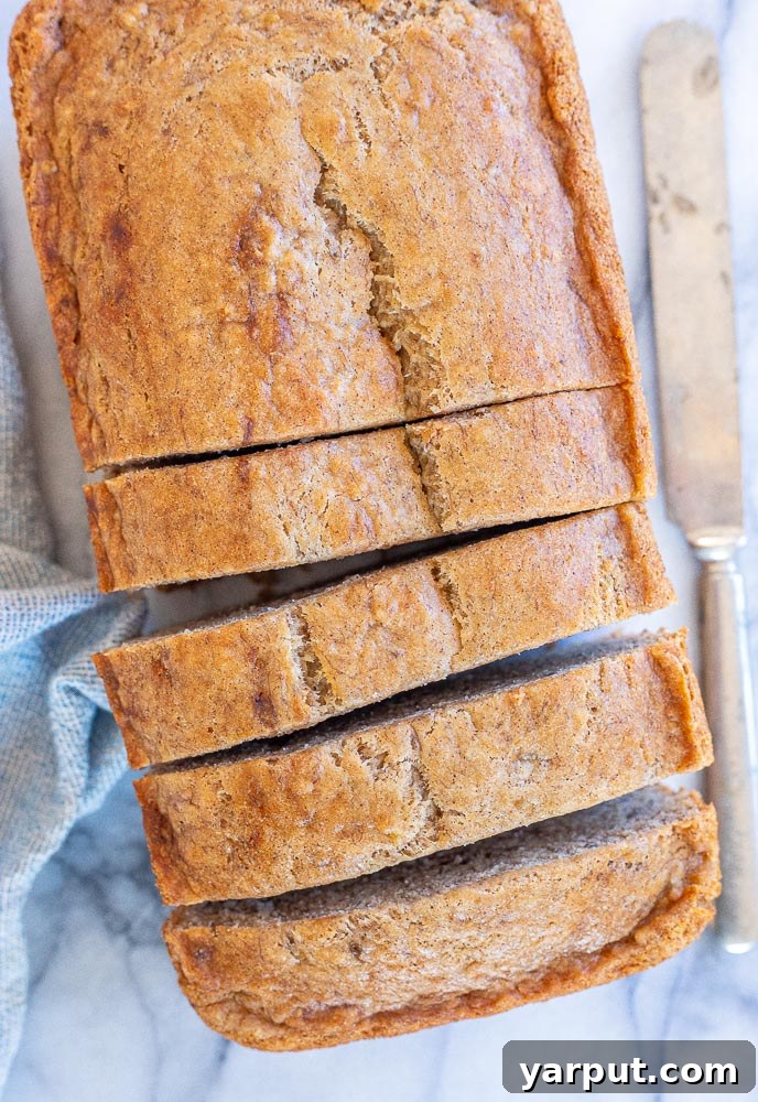 Decadent Vegan Banana Bread 2 A freshly baked loaf of Vegan Banana Bread, golden brown and inviting, sitting on a cooling rack.