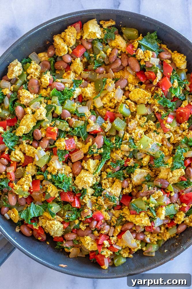 Plant-Powered Breakfast Bowls 4 Close-up of a skillet filled with richly seasoned veggie-packed tofu scramble and pinto beans