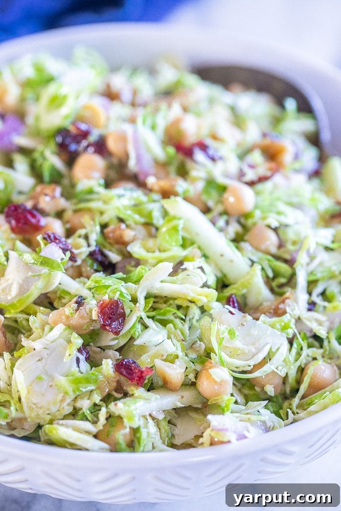 Vibrant Shaved Brussels Sprout Salad 5 Appetizing close-up view of a healthy, raw Shaved Brussels Sprout Salad, ready to be served.