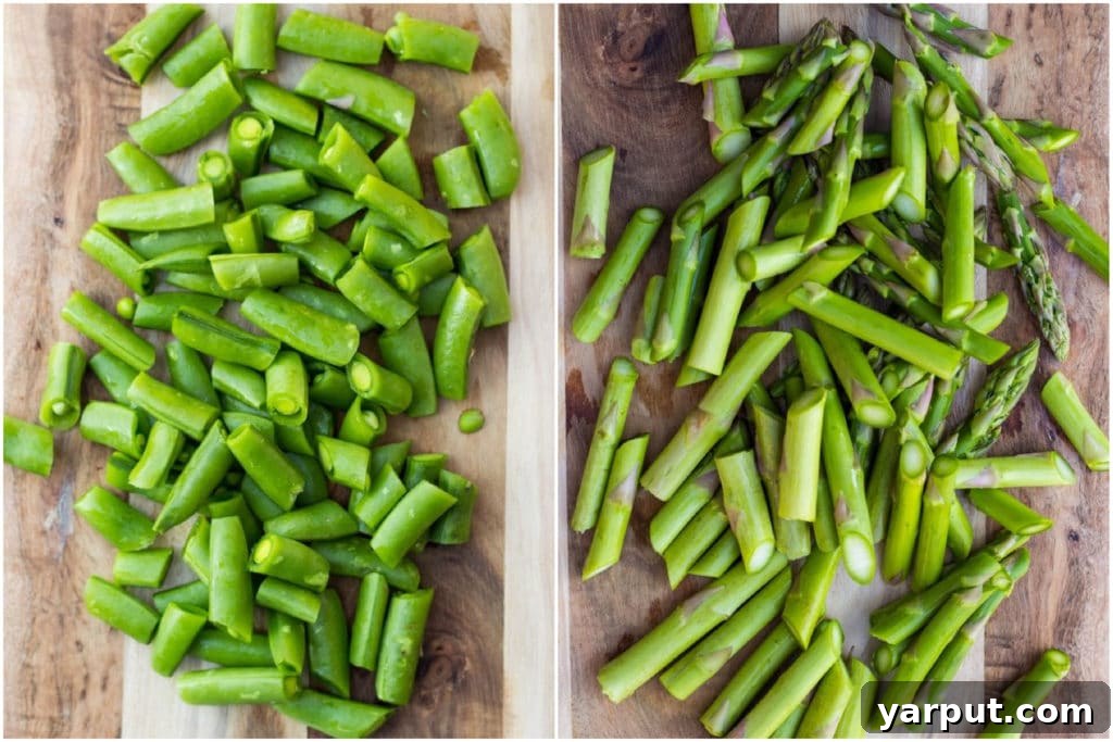Close-up of chopped asparagus and halved sugar snap peas on a cutting board, prepped and ready for blanching or sautéing in a spring quinoa salad recipe.