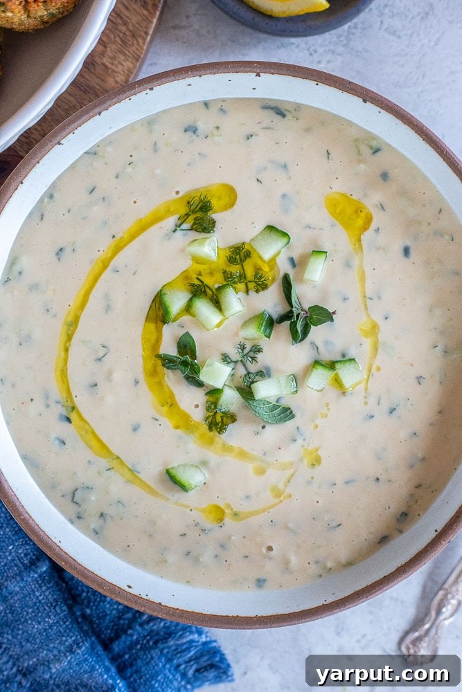 Creamy Vegan Tzatziki Dip 7 A close-up shot of a bowl of Mediterranean-inspired vegan tzatziki sauce, highlighting its smooth, creamy texture and fresh herb garnish.