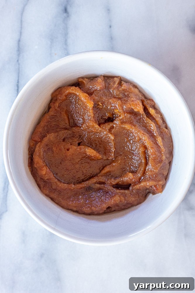 A close-up view of velvety smooth date paste in a rustic bowl, ready to be used as a delicious and healthy natural sweetener in any recipe.